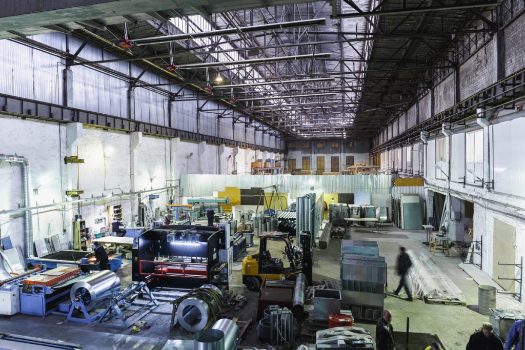 Industrial workshop or hangar on production of ventilation systems. Metalworking factory abstract background with lots of equipment and machinery, toned